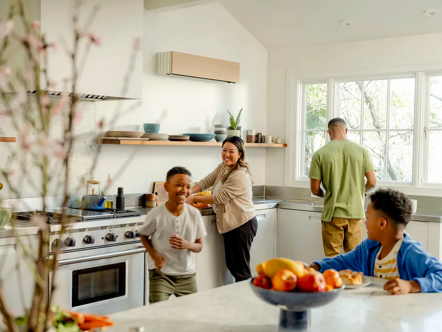 A family in a kitchen with a Quilt indoor unit positioned on a wall above the counter.